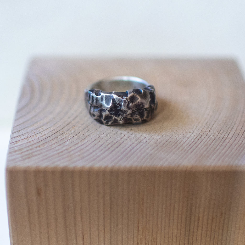 The Rock – handmade sterling silver ring with raw hammered texture and dark oxidized details, artisan unisex jewelry with rugged, earthy style